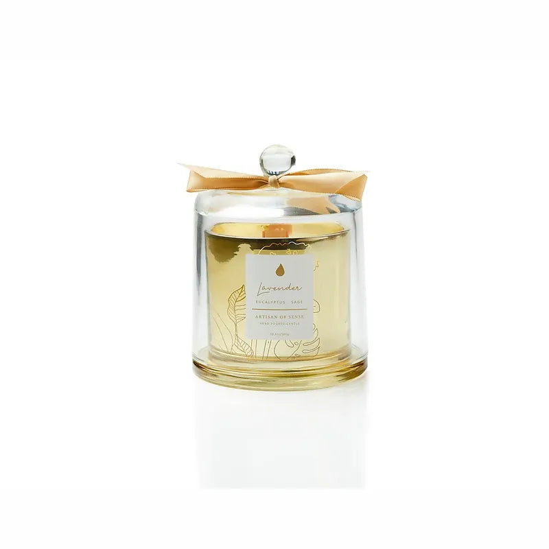 The warm light of a handcrafted essential oil soy candle, featuring an FSC-certified wooden wick for a gentle crackle. It rests within a sophisticated gold glass jar, protected by a dome, and comes in sustainable packaging, perfect for giving. Scent: Lavender . Eucalyptus . Sage.