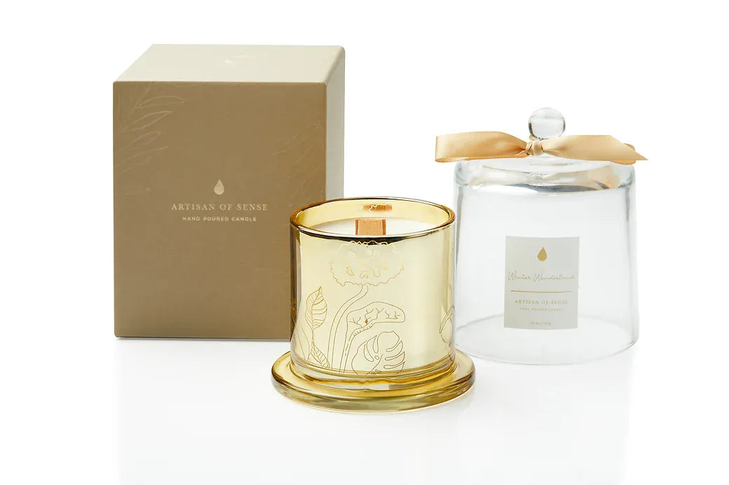 Discover the charm of a crackling wooden wick candle with natural fragrances, a hand-crafted soy creation nestled in a chic gold glass jar and covered by a glass cloche. Its unique aesthetic and eco-friendly packaging make it an excellent gift choice. Scent: Winter Wonderland.
